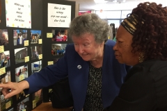 Sr Angela Hallahan discusses the picture display with a guest